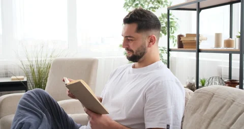 Man reading a book on the sofa Video stock 150025091
