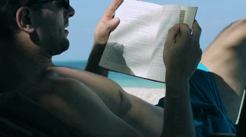 Man reading book on sunbed Stockbeeldmateriaal 39069888