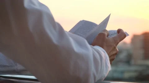 Man reading a book at sunset on the balcony, rear view Stock Footage 215024962