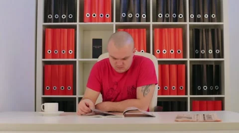 Man reading a book at the table in office Video stock 46819547