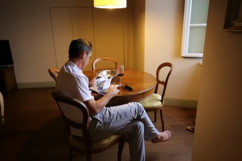 Man reading book at table Stock Photos