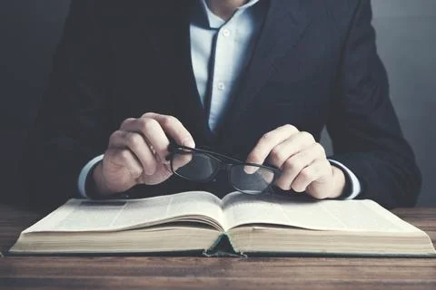 Man reading book on table Stock Photos