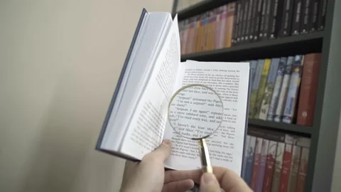 A man reading a book using a magnifying glass. Point of View Shot. POV video. Video stock 237941463