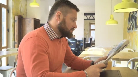 Man reading, browsing, daily newspaper, profile, in cafe, steadicam shot Vidéo 73266519