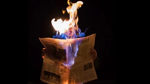 Man reading burning newspaper - Slow motion Stock Footage 88219609