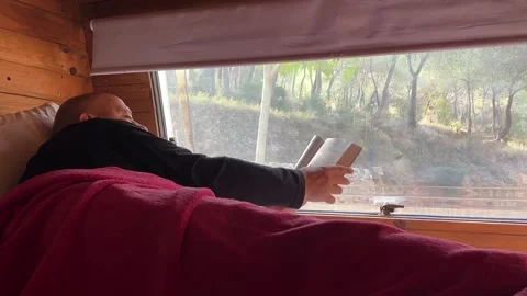 Man reading in camper van bed 4K Stock Footage 319351348