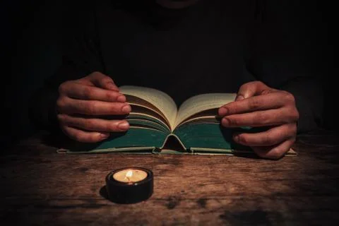 Man reading by candle light Stock Photos