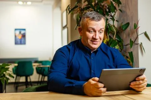 Man Reading Data on Tablet During Work Session Stock Photos