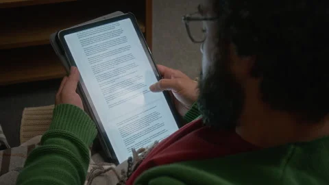 Man Reading Digital Book on Tablet Screen Scrolling Pages Stock Footage 341674024