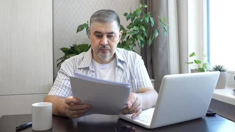 Man Reading Documents at Work Desk Stock Photos