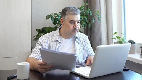 Man Reading Documents at Work Desk Stock Photos