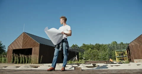 Man reading draft on construction site in countryside. Full body male builder Stock Footage 141682257