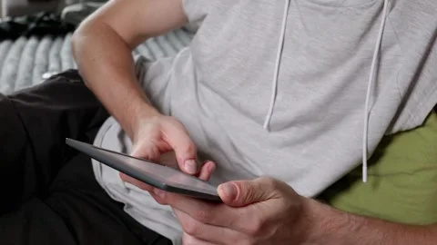 Man Reading Electronic Book on Tablet While Relaxing Indoors Stock Footage 339216879