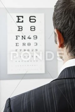 A Man Reading An Eye Chart, Over The Shoulder View