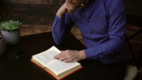 Man reading a hardcover book Stock Footage 85447532