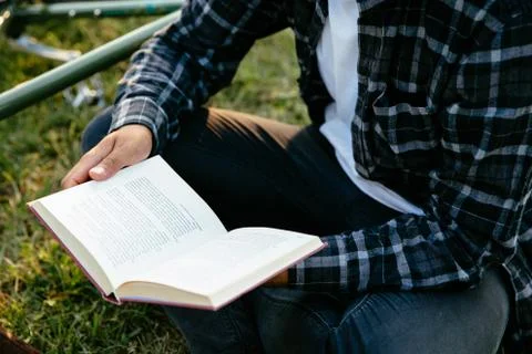 Man reading interesting book while sitting on grass Stock Photos
