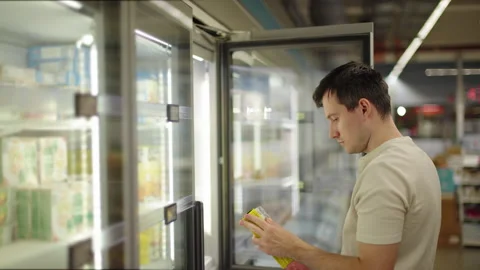 Man Reading Label on Packaged Product at Supermarket Freezer Stock Footage 342349785