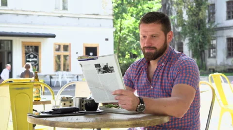 Man reading magazine during breakfast Vídeo Stock 67629079