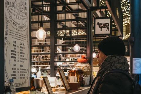Man reading the menu at a stall in Spitalfields Market, London, UK. Selective Stock Photos