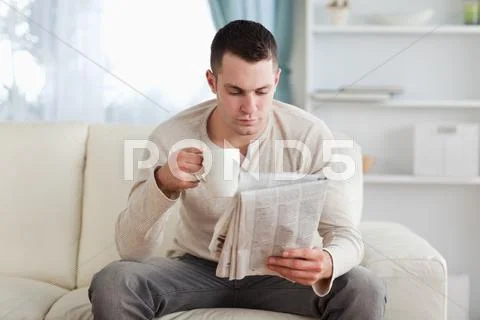 Man reading the news while drinking a coffee Stock Photos
