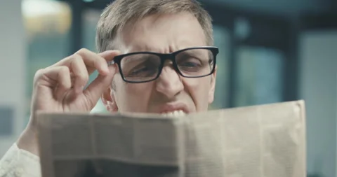 Man reading a newspaper and having a vision problem Stock Footage 168367688
