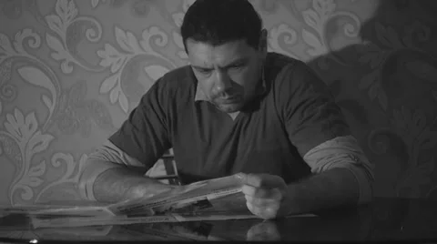 Man reading a newspaper with artificial lighting Vídeo Stock 35584522