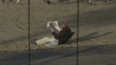 Man reading a newspaper on beach Stock Footage 11635473