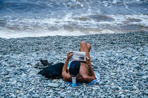 Man reading the newspaper on the beach Stock Photos