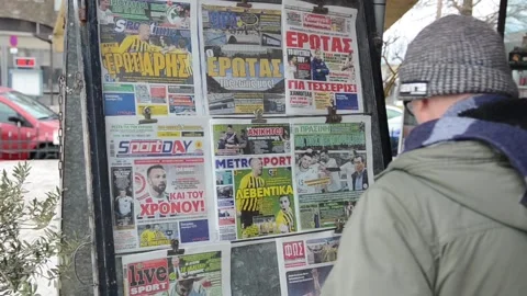 Man reading newspaper in a front of the store. Newspapers stall. Kiosk Stock Footage 131798619