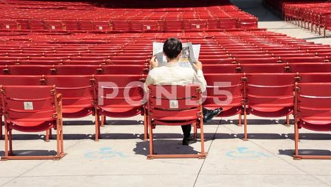 Man reading a newspaper in Jay Pritzker Pavilion in Millennium Park, Chicago. Stock Photos