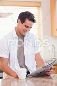 Man reading newspaper in the kitchen Stock Photos