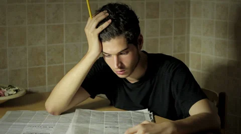 A man reading in a newspaper looking for a job - seeking work Stock-Footage 28509746