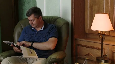 A man reading a newspaper while sitting in a chair. Read the latest press. Stock Footage 96497715