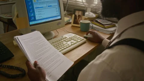 Man Reading Paper Document and Working on Retro Computer Stock Footage 341422876