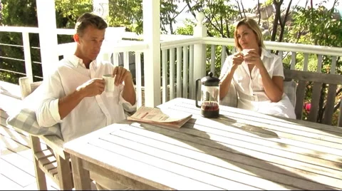 Man reading paper on veranda Stock Footage 43684628