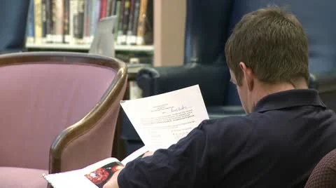 Man reading papers in a library Stock Footage 10774528