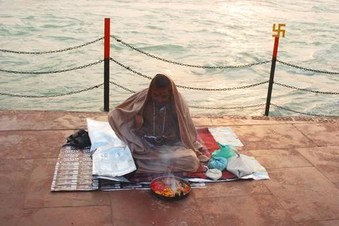 Man reading scriptures on bank of river ganga ganges at har ki pouri in Ha... Stock Photos