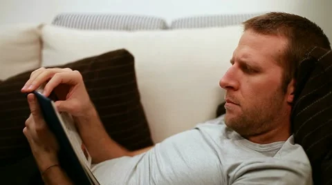 Man reading on sofa Stock Footage 11324936