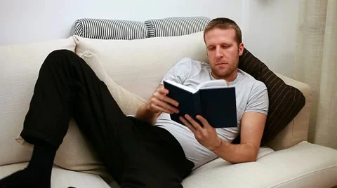Man reading on sofa Stock Footage 11330164