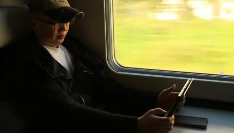 Man reading with tablet PC during train ride Stock Footage 10704734