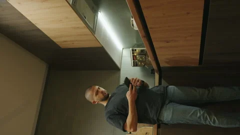 Man reading text message, online news or browsing internet in kitchen at home Stock Footage 257543712