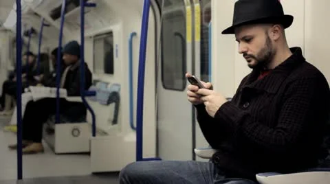 Man reading text messages on a mobile on a tube train Vídeo Stock 21022529