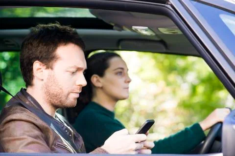 Man reading text messages while riding in car Stock Photos