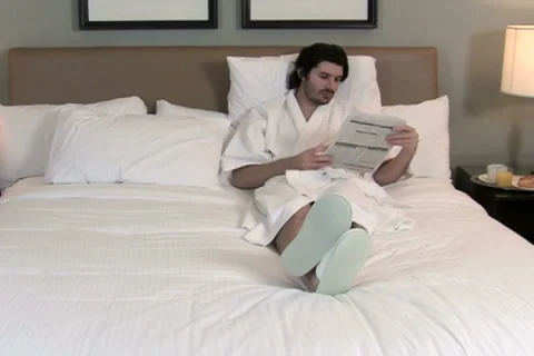 Man reads in bed with breakfast V3 - NTSC Stock Footage 2239560