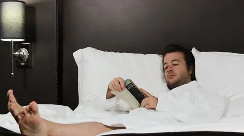 Man reads in bed V2 - HD Stock Footage 12234099