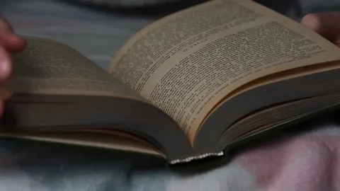 A man reads a book lying in bed. Time for yourself, rest and hobbies. Stock Footage 223371957