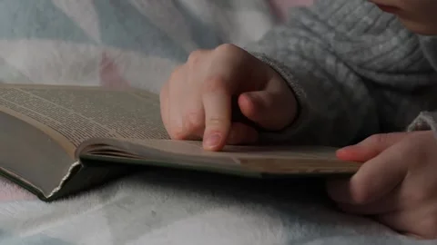 A man reads a book lying in bed. Time for yourself, rest and hobbies. Stock Footage 223371963