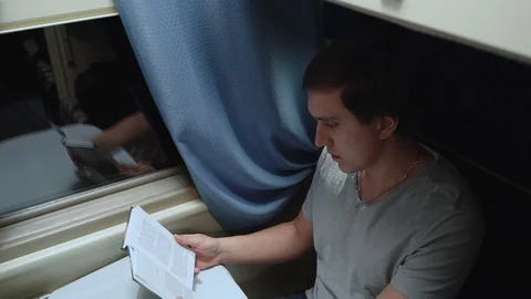 Man reads a book in a train Stock Footage 105260032