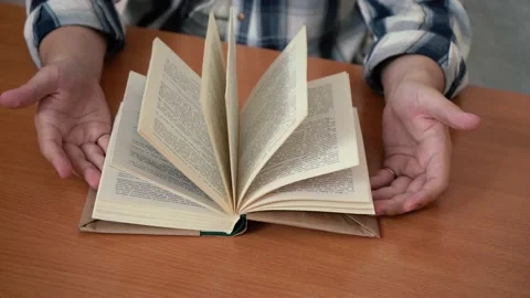 Man reads a book while sitting at the table. 4k footage Stock Footage 156727680