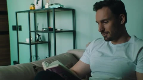 Man reads a book while staying at home Stock Footage 131398633